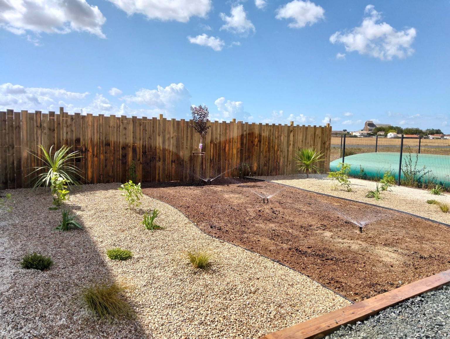 Jardin finalisé avec massifs et espace minéral près de la piscine